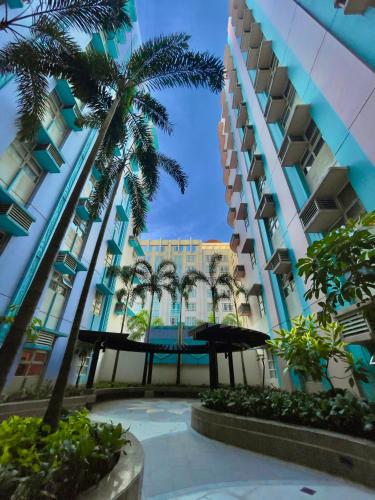 a courtyard with palm trees and a building at NAIA Terminal 3 Condo Newport with WIFI Netflix Pool in Manila