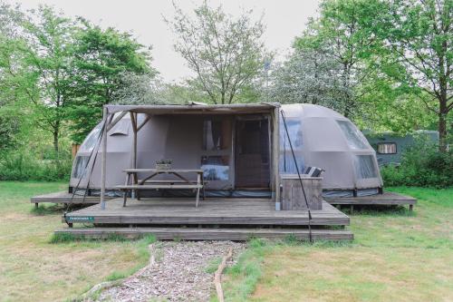 a tent sitting in a field with a table at Panorama in Hoogersmilde