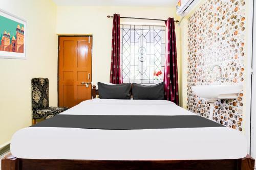 a bedroom with a white bed and a sink at Hotel O Casa De Elevterio in Goa