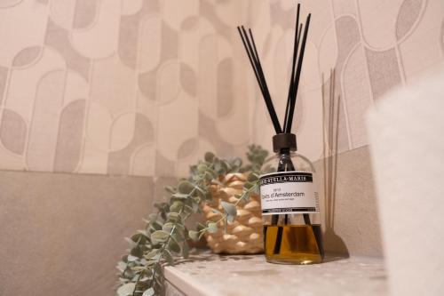 a bottle of oil with sticks in it next to a pineapple at Bed & breakfast De Loeghoeve in Anderen