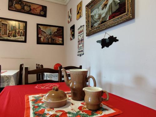 a table with two tea pots on a red table cloth at Hotel "Red House" in Akhaltsikhe