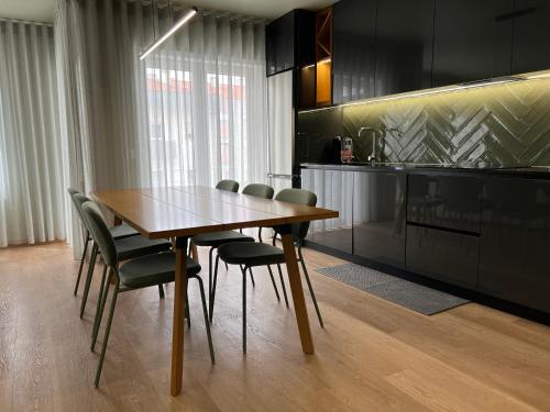 a dining room with a wooden table and chairs at Casa de Lencastre, Refúgio elegante entre tradição e modernidade in Viana do Castelo