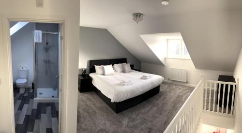 a bedroom with a large bed and a staircase at Kingfisher House by Blue Skies Stays in Stockton-on-Tees