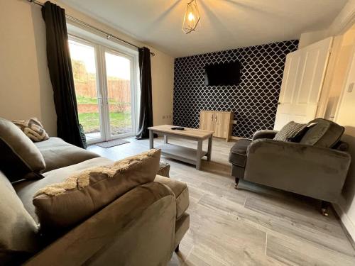 a living room with a couch and a table at Kingfisher House by Blue Skies Stays in Stockton-on-Tees