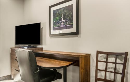 a computer desk with a television and a chair at My Place Hotel-Savannah Airport/Pooler, GA in Savannah