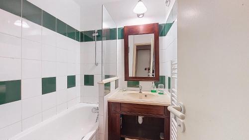 une salle de bain avec un lavabo, une baignoire et un miroir dans l'établissement S-Pinsolle 02-Soustons plage Appartement deux pièces dans résidence avec piscine proche du golf, à Soustons