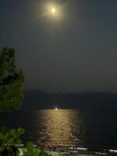 a full moon over a body of water at night at Sunrise Grigoleti in Grigoleti