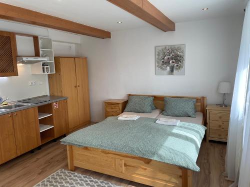 a small bedroom with a bed and a kitchen at Penzion Agape in Luhačovice