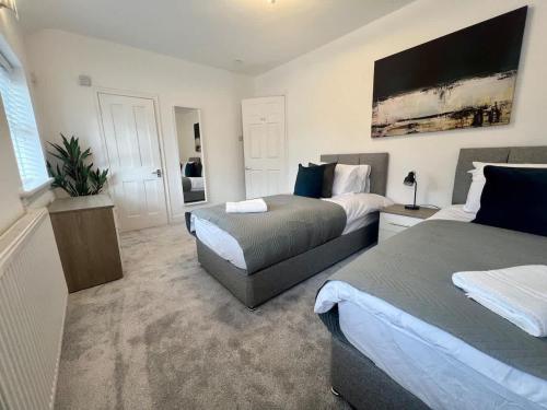 a hotel room with two beds and a couch at Cotswold House in Stockton-on-Tees