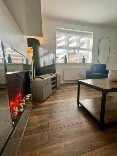 a living room with a fireplace and a table at Cotswold House in Stockton-on-Tees