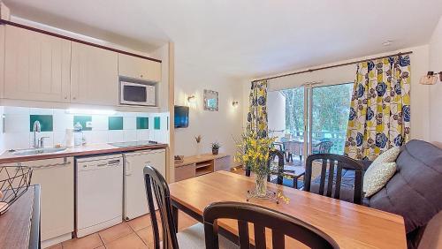 - une cuisine et une salle à manger avec une table et un canapé dans l'établissement S-Pinsolle 02-Soustons plage Appartement deux pièces dans résidence avec piscine proche du golf, à Soustons