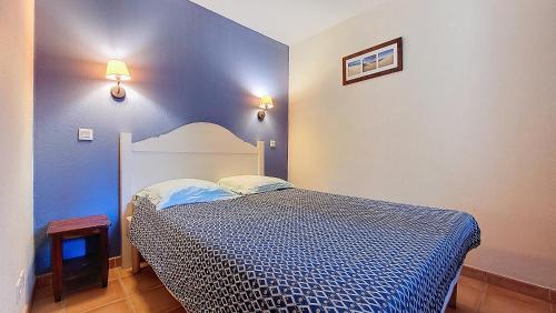 une chambre avec un lit avec un mur bleu dans l'établissement S-Pinsolle 02-Soustons plage Appartement deux pièces dans résidence avec piscine proche du golf, à Soustons