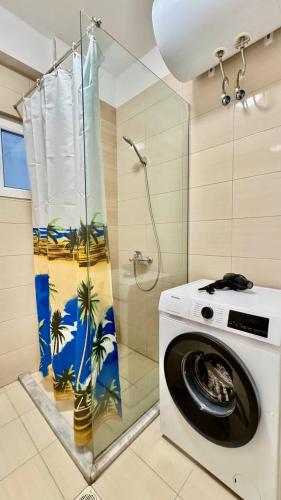 una lavadora en un baño con ducha en Your Comfy Apartment, en Sarandë