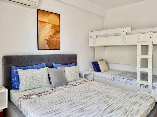 un dormitorio con una cama y dos literas en Your Comfy Apartment, en Sarandë