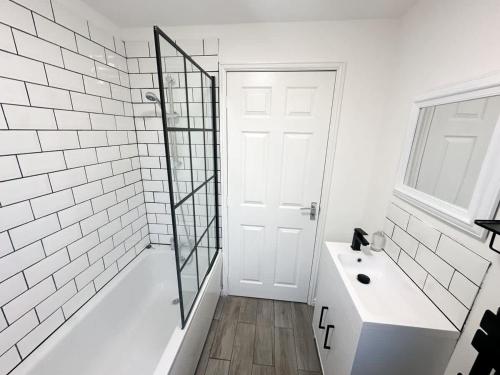 a white bathroom with a shower and a sink at Beck House by Blue Skies Stays in Middlesbrough