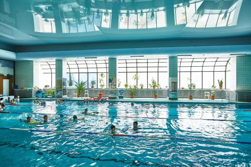 a group of people swimming in a swimming pool at Gavan Hotel in Vladivostok