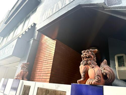 a statue sitting on the ledge of a building at GRAND HOTEL SHISA St OKINAWA グランドホテル シーサーストリート沖縄 in Urazoe