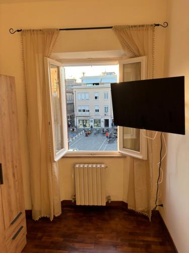 a flat screen tv in a room with a window at XX Settembre 43 n2 in Fano