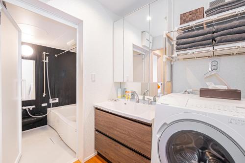 a bathroom with a washing machine and a sink at Ikebukuro Shopping Street 3BR in Tokyo