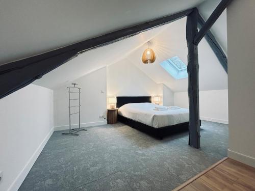 une chambre avec un lit dans un grenier dans l'établissement 2 Clairmarais T2 en duplex proche gare centre, à Reims