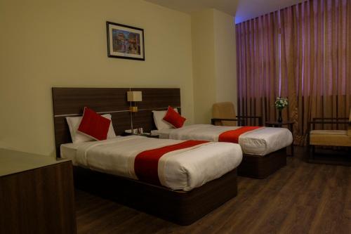 a hotel room with two beds with red pillows at Hotel Regal Airport in Kathmandu
