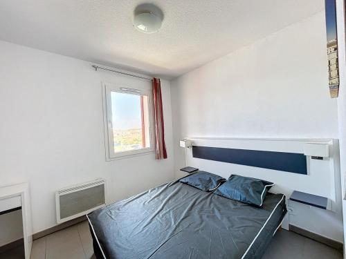 ein Schlafzimmer mit einem Bett und einem Fenster in der Unterkunft 3312-T3 dans une résidence avec piscine in Argelès-sur-Mer