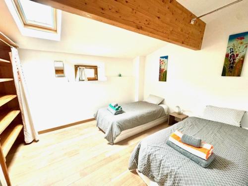 une chambre avec deux lits dans une pièce dans l'établissement Les Lavandes, à Eymet