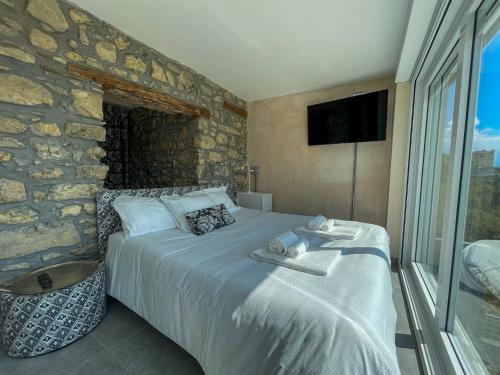 a bedroom with a bed and a stone wall at IseoLakeRental - Dove il Lago Brilla in Vigolo