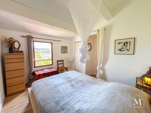 une chambre avec un grand lit et une fenêtre dans l'établissement Maisonnette au calme avec jardin cosy à Sanary, à Sanary-sur-Mer