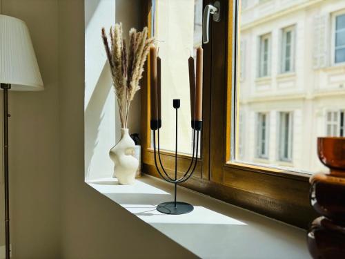 un rebord de fenêtre avec des vases et des fleurs dans une pièce dans l'établissement Le Sainte Rose Standing, Cannes center on foot, à Cannes