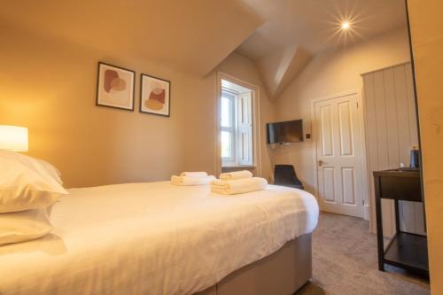 a bedroom with a bed with towels on it at Dalrigh House in Oban