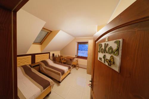 a attic bedroom with two beds and a window at Pokoje U SABI in Wisła