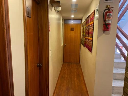a hallway leading to a door in a room at HOSTAL Aly 3 in Otavalo
