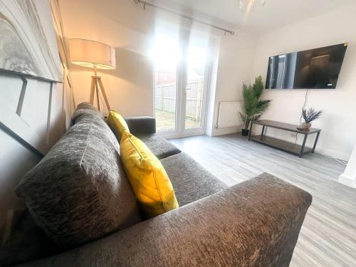 a living room with a couch with a yellow pillow on it at Ruby Place by Blue Skies Stays in Hartlepool