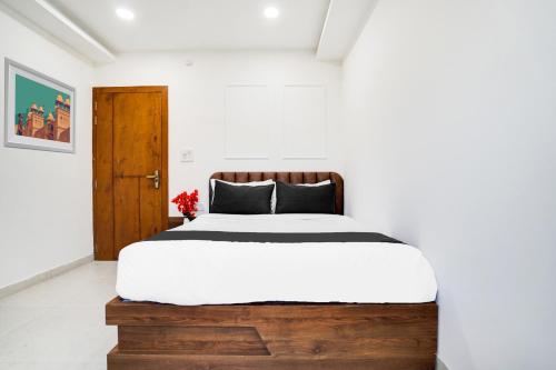 a bedroom with a large bed with a wooden headboard at Hotel O Heaven in Gwalior