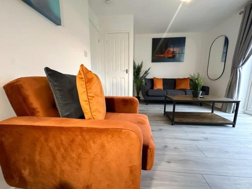 a living room with an orange couch and a table at Edison House by Blue Skies Stays in Stockton-on-Tees