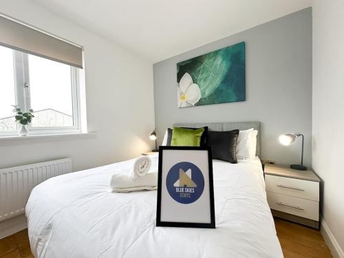 a white bed with a sign on it in a bedroom at Poppy House by Blue Skies Stays in Stockton-on-Tees