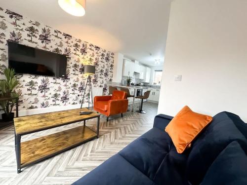 a living room with a blue couch and a table at Poppy House by Blue Skies Stays in Stockton-on-Tees