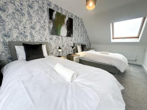 a bedroom with two white beds and a window at Poppy House by Blue Skies Stays in Stockton-on-Tees