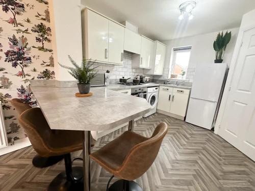 a kitchen with a marble table and chairs in it at Poppy House by Blue Skies Stays in Stockton-on-Tees
