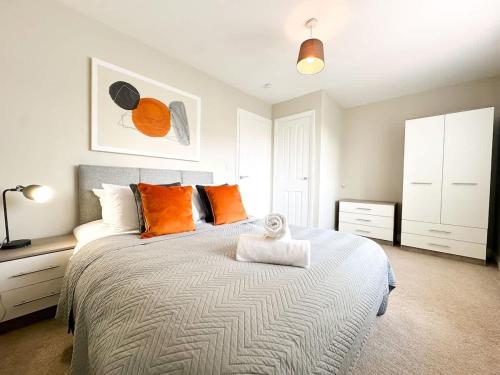 a bedroom with a large bed with orange pillows at Mable House by Blue Skies Stays in Redcar