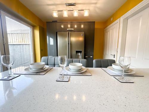 a dining room with a table with wine glasses on it at Mable House by Blue Skies Stays in Redcar