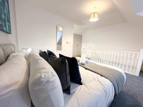 a large white bed with pillows on it in a room at Curlew Place by Blue Skies Stays in Stockton-on-Tees