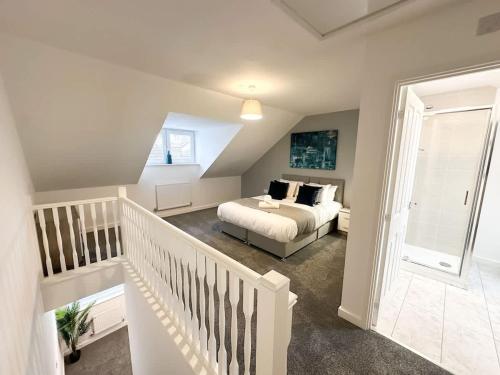 a white bedroom with a bed and a staircase at Curlew Place by Blue Skies Stays in Stockton-on-Tees