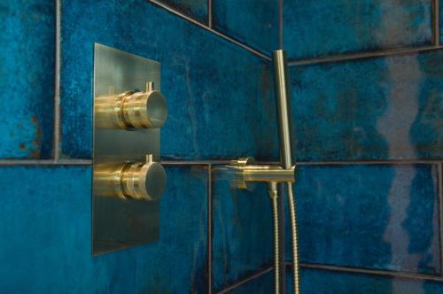 a blue tiled wall with a shower in a bathroom at Dalrigh House in Oban