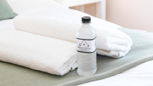 a bottle of water sitting on a bed with towels at Botha House in Pennington