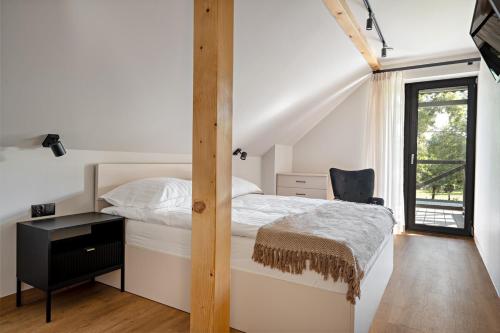 a bedroom with a bed and a desk and a window at ApartHouse 45B in Radomierzyce