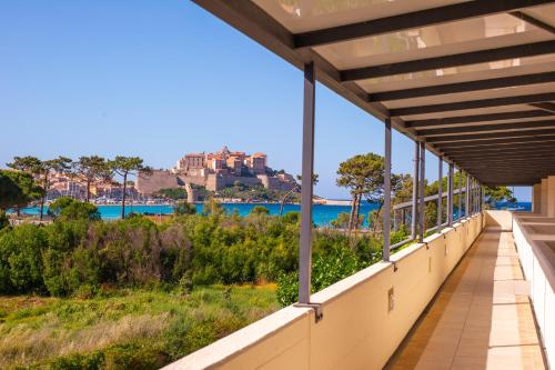 a balcony with a view of the water at Calvi Hôtel in Calvi