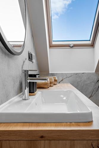 a bathroom with a sink and a window at ApartHouse 45B in Radomierzyce