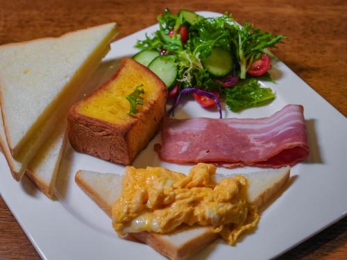 a plate of food with meats and bread and a salad at Yangshuo Lisa Boutique Hotel in Yangshuo